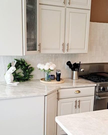 A renovated kitchen with tile backsplash and stone counters by Nitzband Tile & Renovations